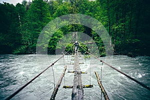Man Traveler hiking on wooden bridge over river