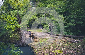Man Traveler hiking on wooden bridge over river