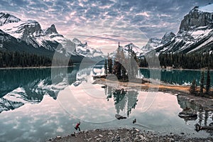 Man traveler jumping on lakeside in Spirit Island on Maligne Lake at Jasper National Park