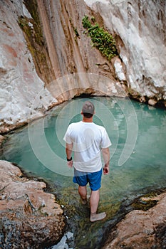 man traveler looking at dimosari waterfall lake at summer time