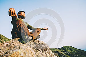 Man traveler meditating yoga at mountains