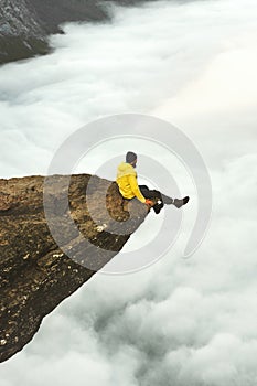 Man traveler meet the dawn sitting on Trolltunga