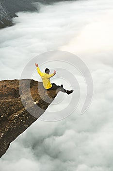 Man traveler meet the dawn on Trolltunga rocky cliff