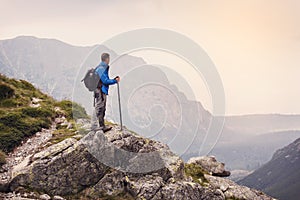 Hiker with backpack standing on top of a mountain