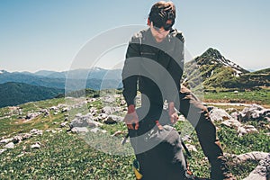 Man traveler packing backpack hiking in mountains