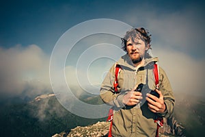 Man Traveler with photo camera and backpack hiking