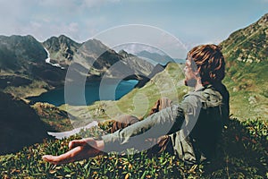 Man traveler raised hands enjoying blue lake in mountains aerial view