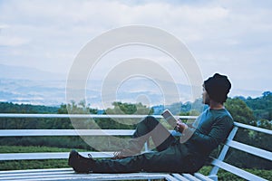 Man traveler is reading book travels nature on the mountain In the fresh air in the north, Chiang Mai.