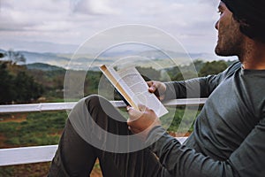 Man traveler is reading book travels nature on the mountain In the fresh air in the north, Chiang Mai.