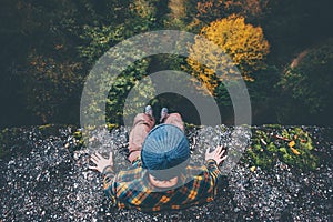 Man Traveler sitting on cliff bridge edge