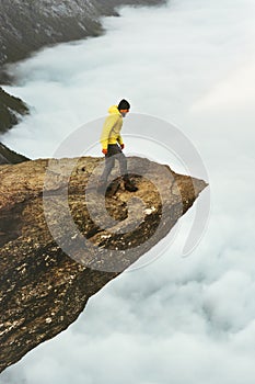 Man traveler on Trolltunga rocky cliff edge mountains