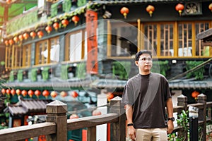 man traveler visiting in Taiwan, Tourist sightseeing in Jiufen Old Street village with Tea House background. landmark and popular