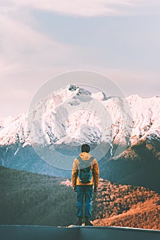 Man traveler walking alone in sunset mountains