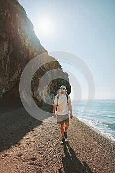 Man traveler walking on empty beach travel lifestyle active summer vacations outdoor