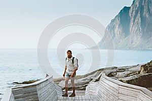 Man traveler walking on seaside exploring Norway travel solo summer vacations