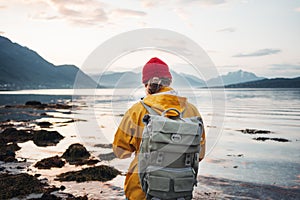 Man traveler wearing yellow jacket with backpack explore scandinavia nature