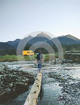 Man traveler with yellow van camping in mountains