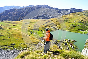 A man traveling alone with a backpack against the backdrop of a mountain valley and Kapetanovo Lake photo