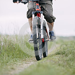 Man traveling riding bicycle along a country road.