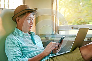 A man traveling by train opening a notebook computer