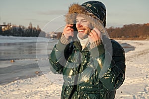 Man traveling in winter, nature. Winter fashion. Green warm coat. Warm clothes for cold season. Sexy man in winter