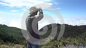 Man traveller at the top of mountain enjoy the view above the clouds.