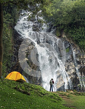 A man traveller walk togather Tent and camping with Mae Tia waterfall