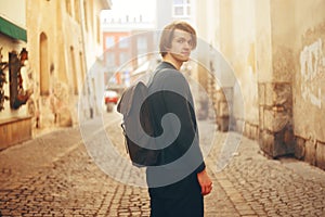 A man travels in Europe. A man smiles, walks through the streets of the old city, with a briefcase.