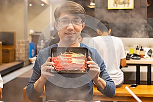 Man with tray of sliced beef