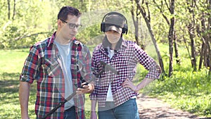 Man treasure hunter explains to a girl how to use a metal detector