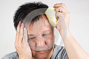 Man treating his injured painful swollen forehead bump with icepack