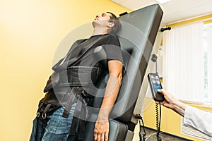 Man on treatment recovery physiotherapy of human spine by stretching with special medical equipment in clinic