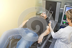 Man on treatment recovery physiotherapy of human spine by stretching with special medical equipment in clinic