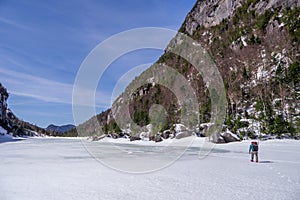 Man trecking across a frozen lake