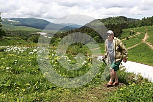 Man trekking across alpine meadow of Lago-Naki plateau