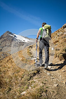 Man trekking in the Alps in a beautiful sunny day. Grand Paradiso National Park. Italy