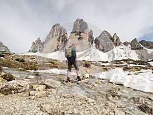 Man trekking in Alps. Sharp peaks stick over clouds