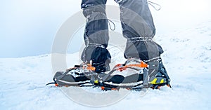 Man trekking snowy mountain using crampons