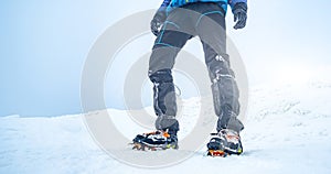 Man trekking snowy mountain using crampons