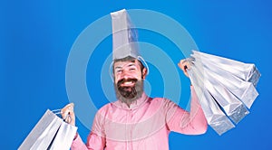 Man with trendy beard and smiling face isolated on blue background. Hipster in pink shirt doing shopping, big spender