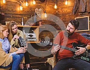 Man with trendy hipster beard composing song, music concept. Bearded man playing guitar. Family spending time listening