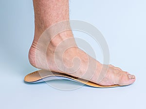 The man tries on the left foot orthopedic insole. Means for the treatment of flat feet.