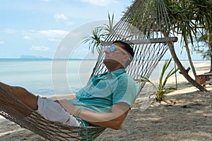 The man in tropics and with the computer Young the beauty lying in a hammock with the laptop in the tropical.