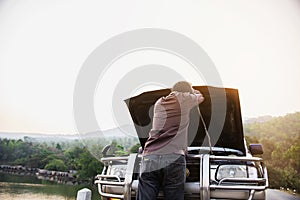 Man try to fix a car engine problem on a local road Chiang mai Thailand