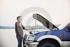 Man try to fix a car engine problem on a local road Chiang mai Thailand