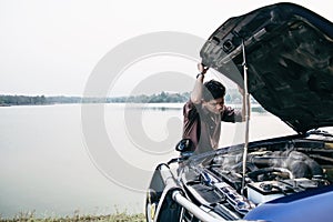 Man try to fix a car engine problem on a local road Chiang mai Thailand