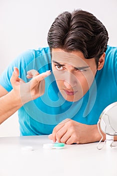 The man trying contact lenses at home