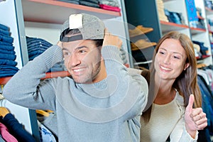 Man trying hat on backwards lady giving thumbs up