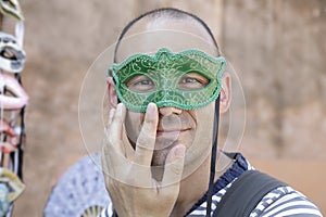 Man trying on one venetian carnival mask