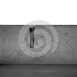 Man trying to climb over wall with business doodles